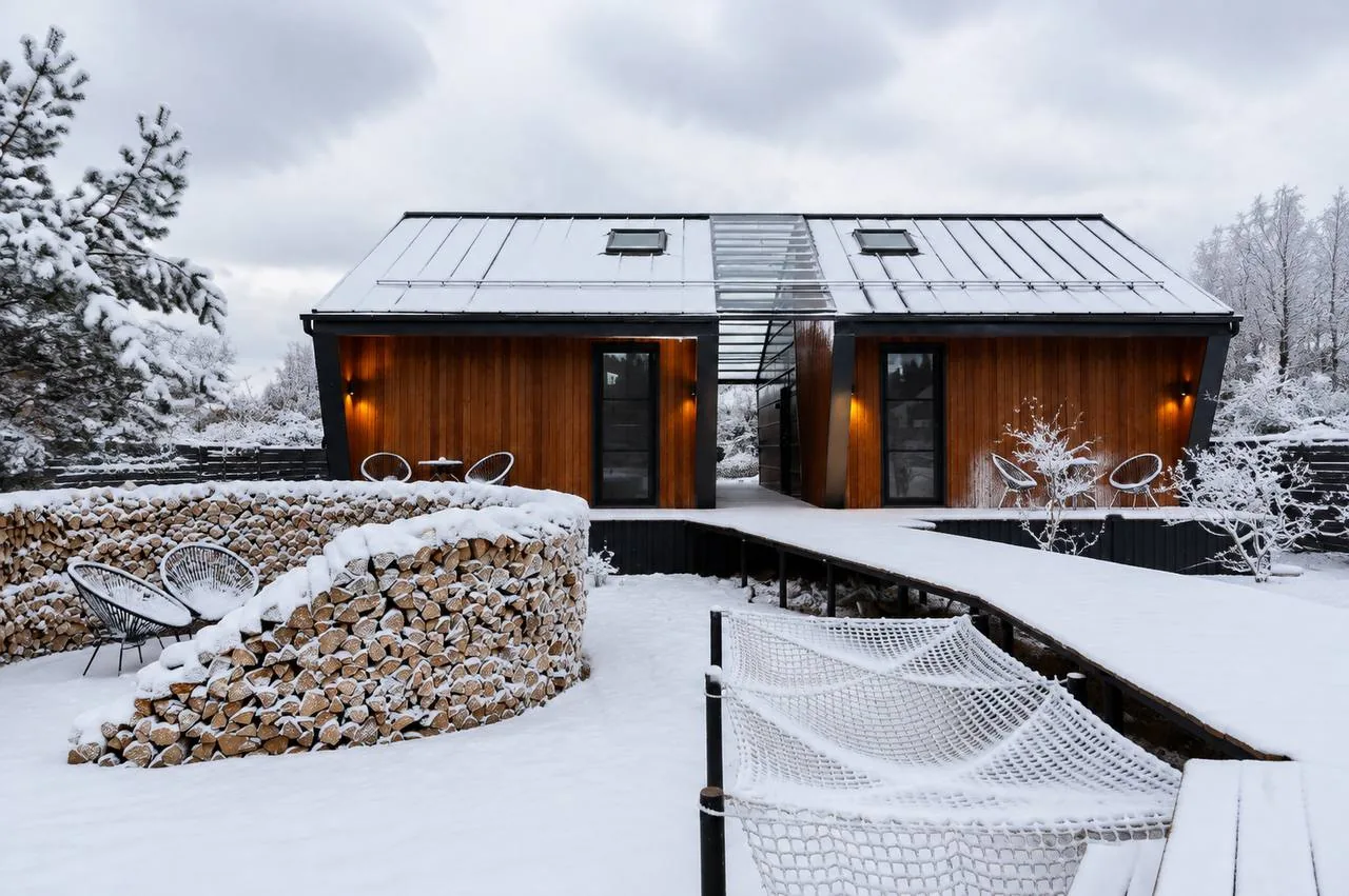 Два барнхауса Wind Houses зимой с тёплым светом в окнах